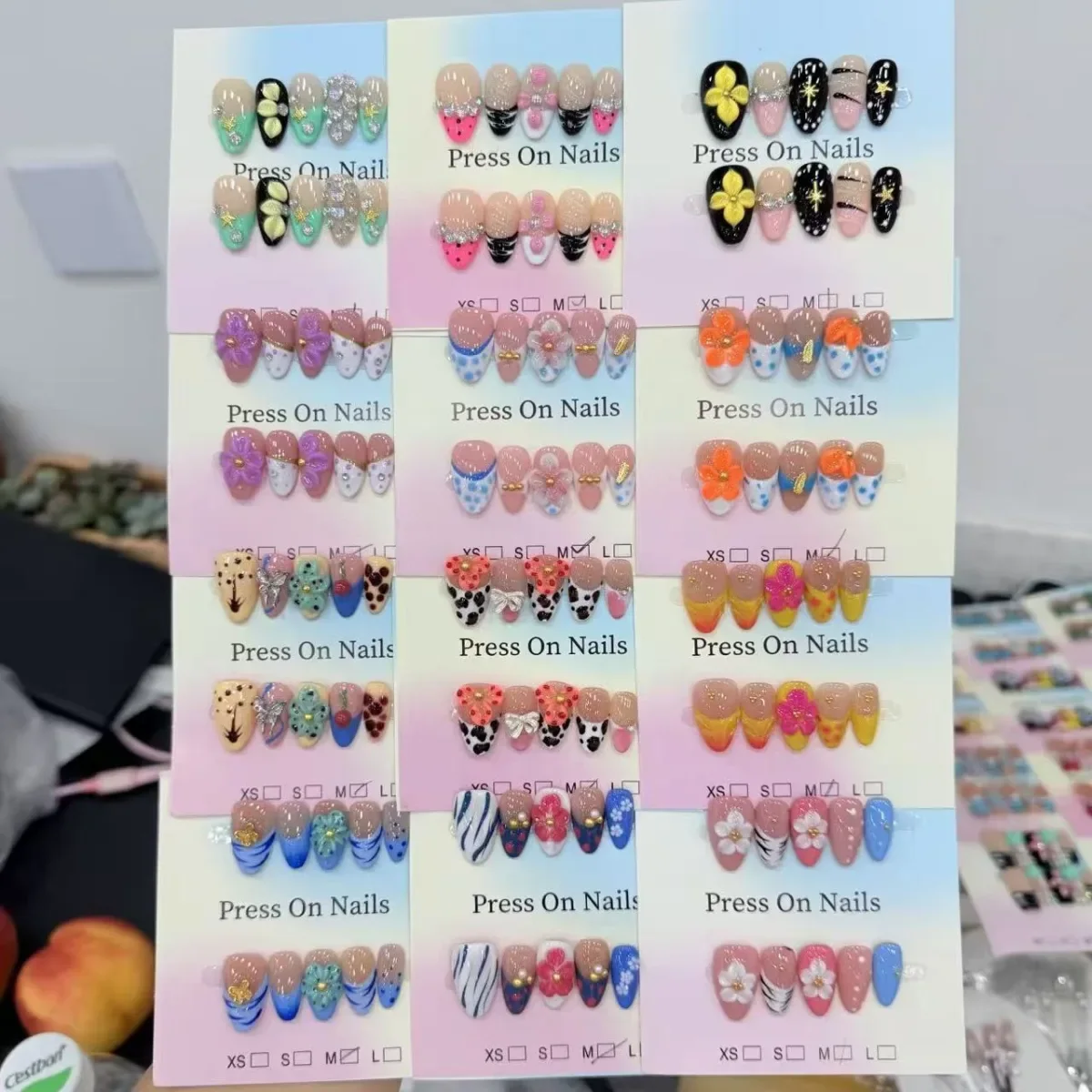 Floral and colorful press-on nail designs mounted on pastel display cards